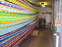Werkstatt mit langen Reihen leuchtend bunt gefärbter Chenille- und Ostergras-Stränge
